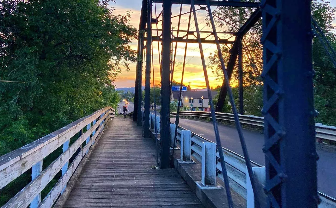 person on bicycle crossing over bridge in Corvallis